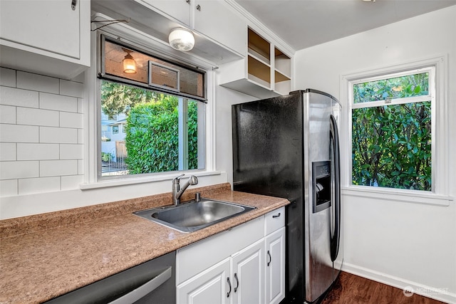 kitchen with sink, appliances with stainless steel finishes, a healthy amount of sunlight, white cabinets, and dark hardwood / wood-style flooring