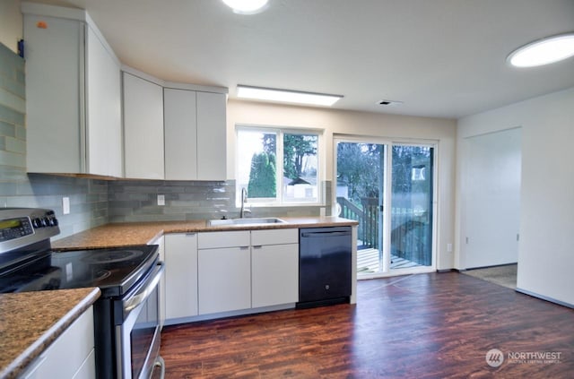 kitchen featuring black dishwasher, sink, white cabinets, decorative backsplash, and electric range