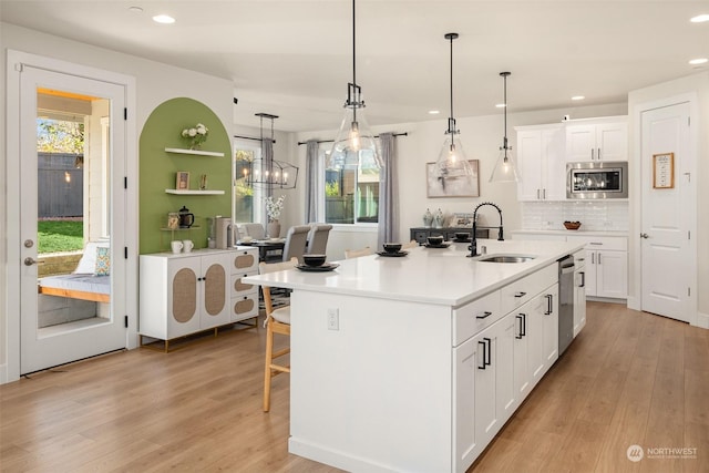 kitchen featuring white cabinetry, appliances with stainless steel finishes, a kitchen island with sink, and sink