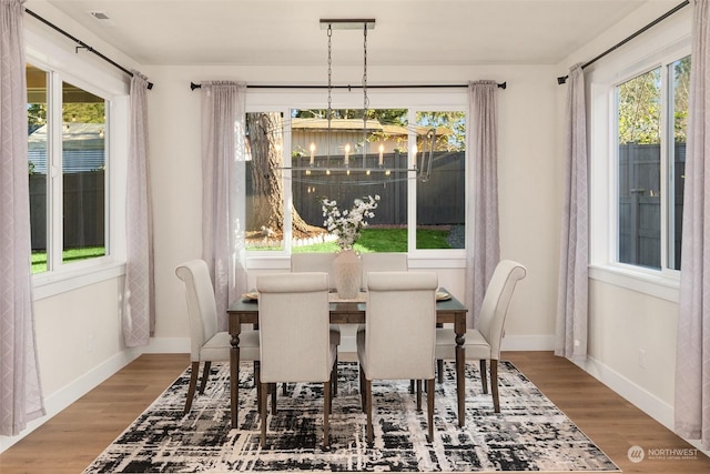 dining area featuring hardwood / wood-style floors and a notable chandelier