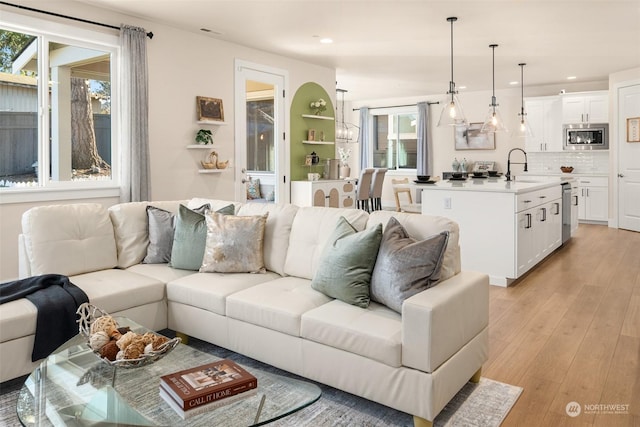 living room featuring sink and light hardwood / wood-style flooring