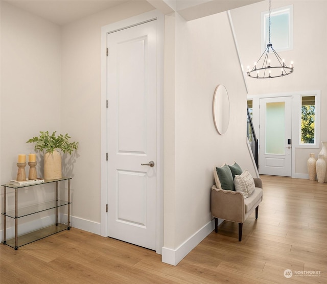 entryway featuring hardwood / wood-style flooring and a chandelier