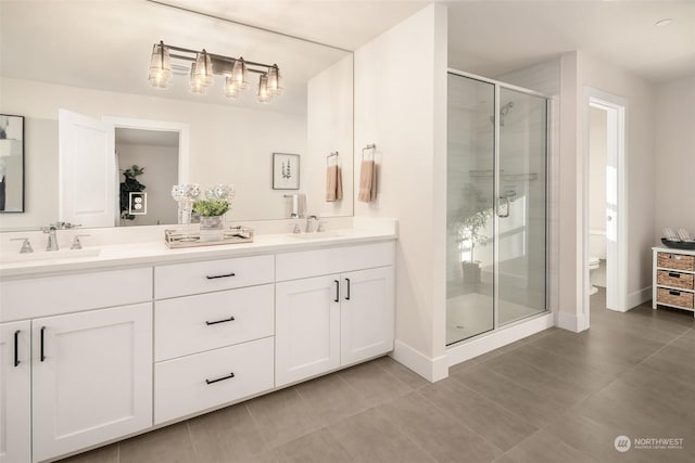 bathroom featuring tile patterned floors, vanity, toilet, and an enclosed shower