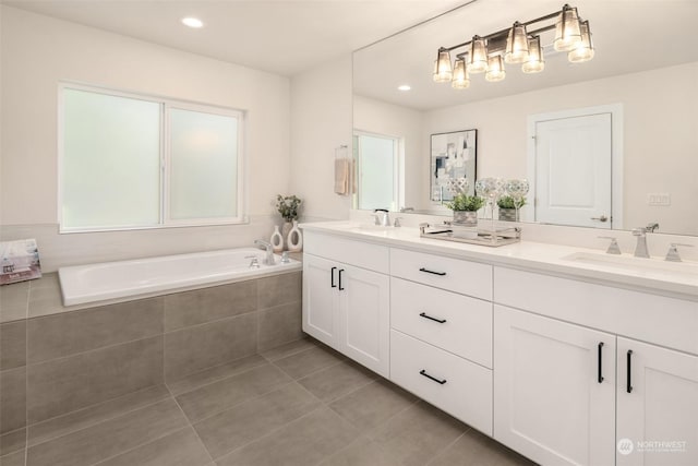 bathroom featuring vanity, a relaxing tiled tub, and tile patterned floors