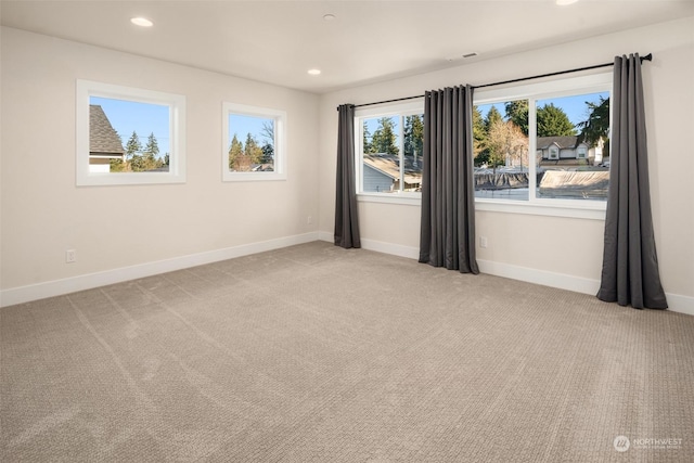 carpeted spare room featuring plenty of natural light