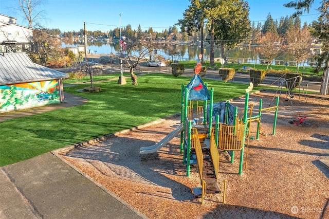 view of play area with a yard and a water view