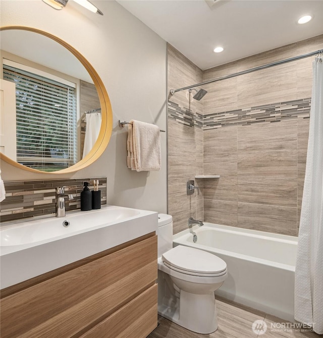 bathroom with shower / bathtub combination with curtain, toilet, and vanity