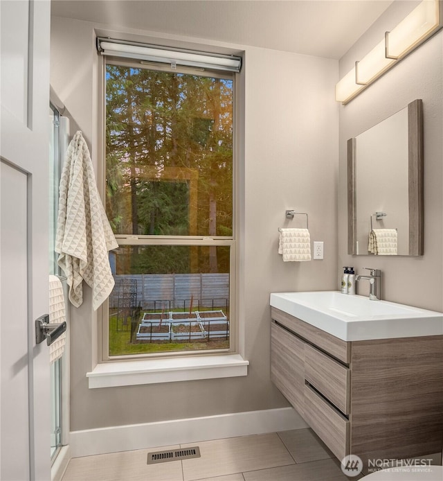 bathroom with baseboards, visible vents, tile patterned flooring, and vanity