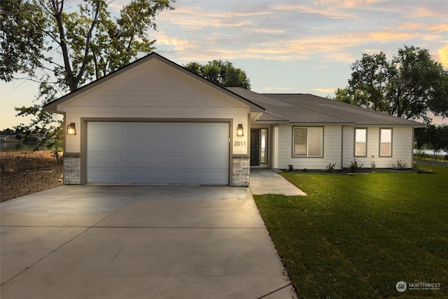 single story home with a garage and a yard