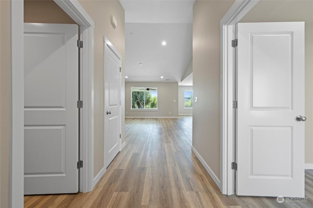 corridor featuring vaulted ceiling and light hardwood / wood-style floors