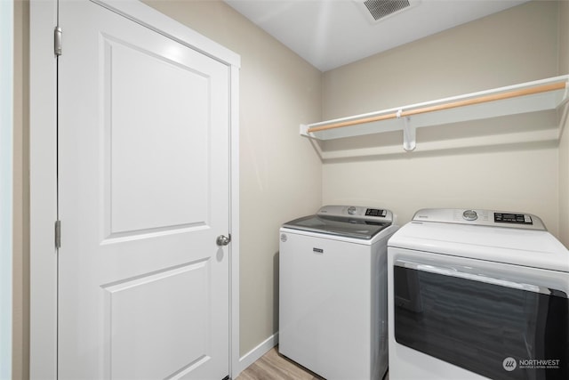 laundry area featuring washer and dryer and light wood-type flooring