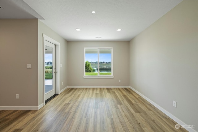 empty room featuring a textured ceiling and light wood-type flooring