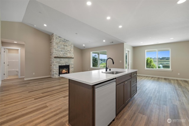 kitchen featuring sink, vaulted ceiling, light hardwood / wood-style flooring, dishwasher, and a kitchen island with sink