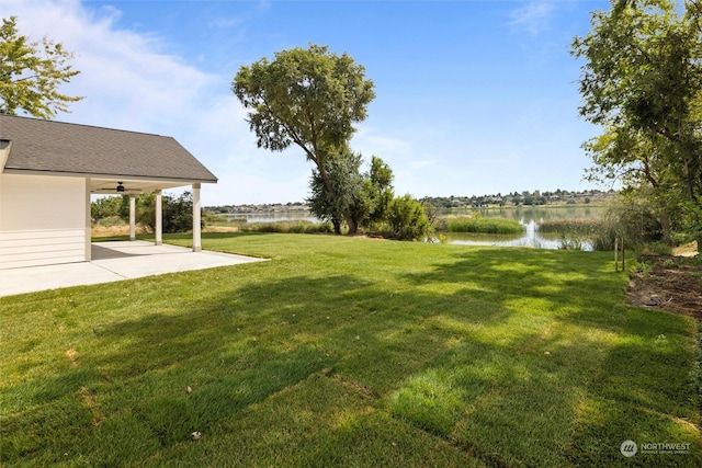 view of yard with a water view, ceiling fan, and a patio