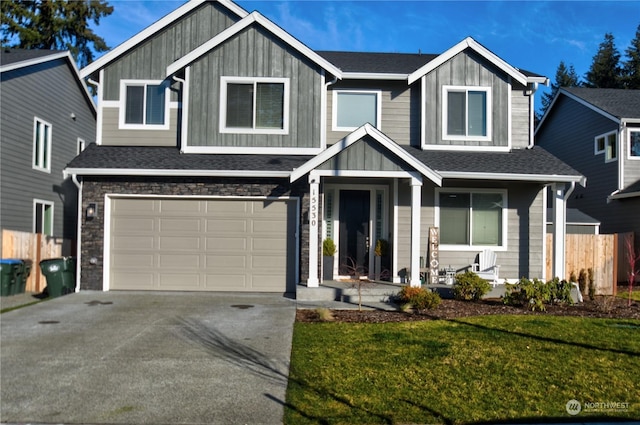 view of front of home with a porch, a garage, and a front lawn