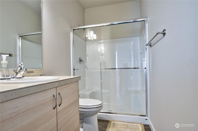 bathroom with vanity, hardwood / wood-style flooring, toilet, and walk in shower