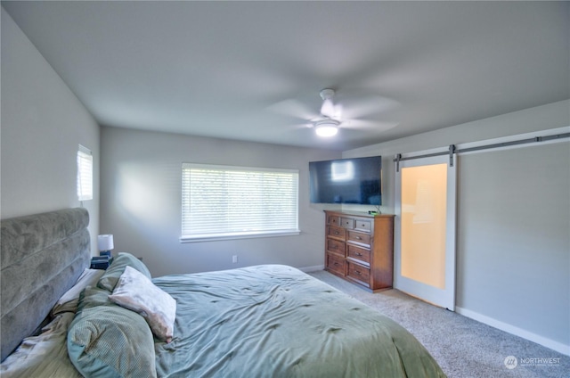 bedroom featuring carpet floors, a barn door, and ceiling fan