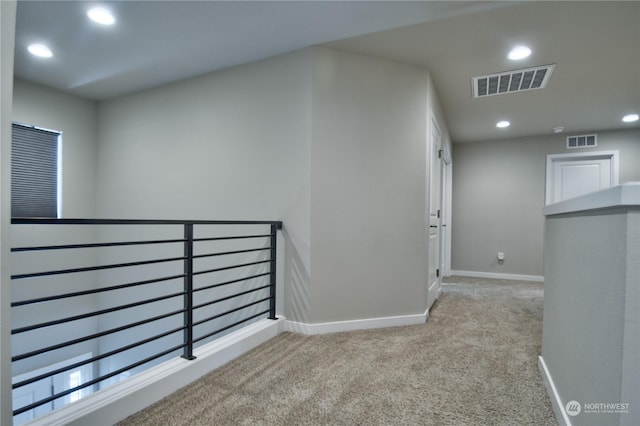 hall featuring light colored carpet