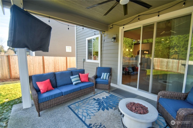 view of patio with ceiling fan and an outdoor living space with a fire pit