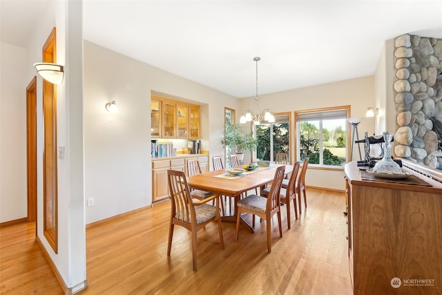 dining space with a chandelier and light hardwood / wood-style flooring