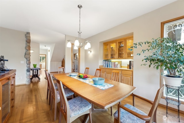 dining room with wood-type flooring and a notable chandelier