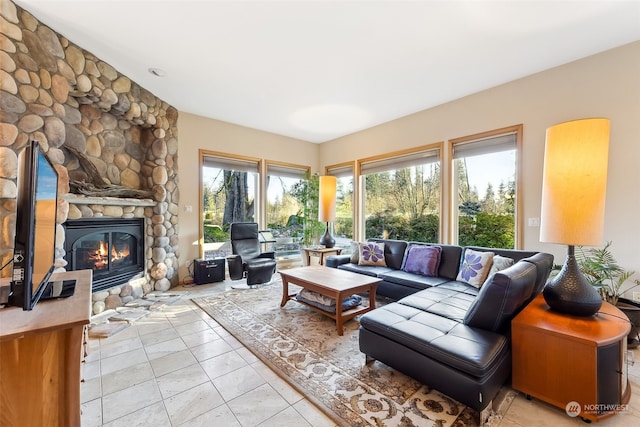 living room featuring light tile patterned flooring and a stone fireplace