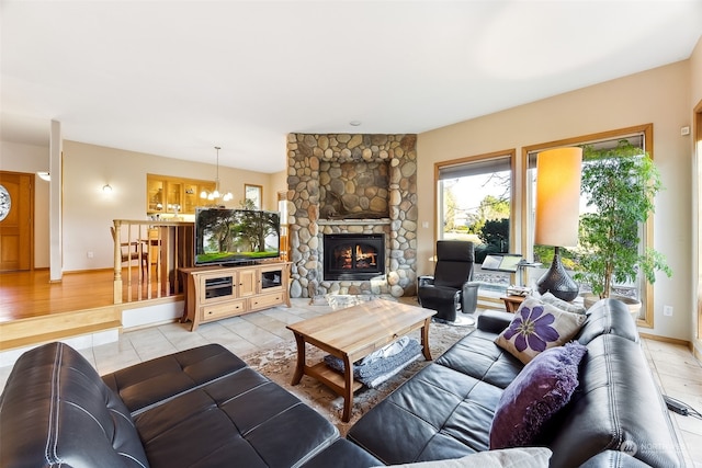 tiled living room with a stone fireplace and a chandelier