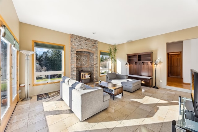 tiled living room featuring a healthy amount of sunlight and a wood stove