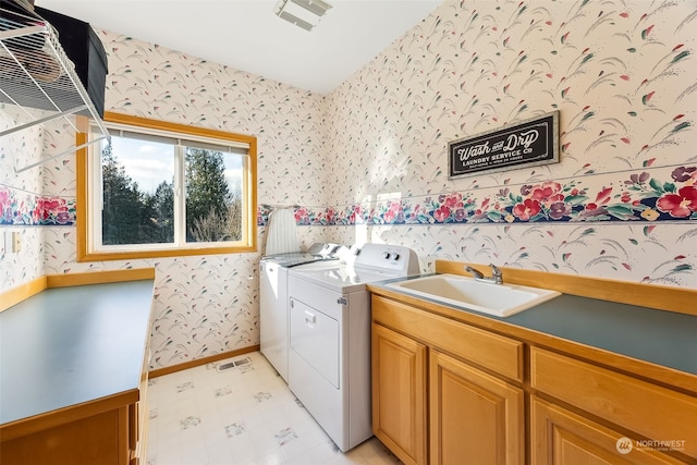 clothes washing area with sink, cabinets, and washing machine and clothes dryer