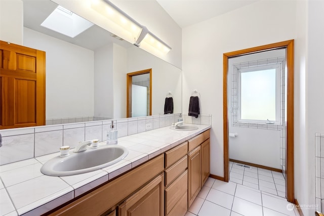 bathroom featuring tile patterned floors, vanity, and a skylight