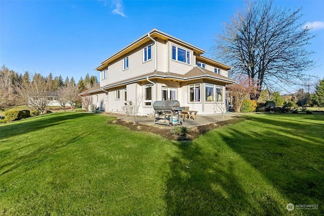 rear view of house featuring a lawn and a patio area