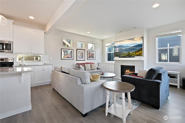 living room with beam ceiling and light hardwood / wood-style floors