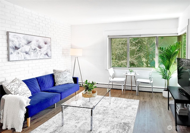 living room featuring wood-type flooring, a baseboard radiator, and brick wall