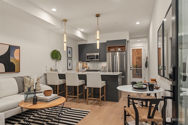 living room with sink and light wood-type flooring