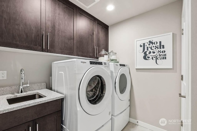 laundry room with cabinets, washing machine and dryer, sink, and light tile patterned floors