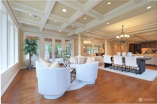 living room with coffered ceiling, beam ceiling, crown molding, and ornate columns