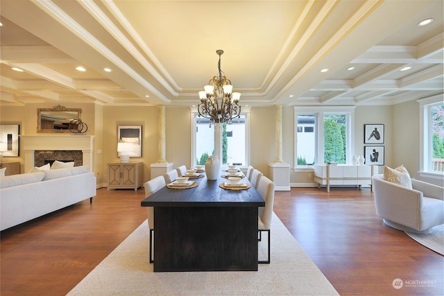 dining room with ornate columns, crown molding, a notable chandelier, and dark hardwood / wood-style flooring