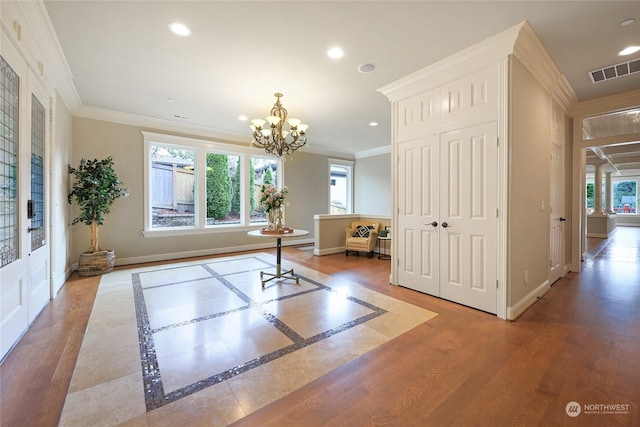 workout room featuring crown molding, hardwood / wood-style floors, and a chandelier