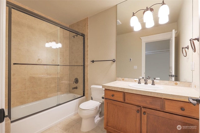 full bathroom with bath / shower combo with glass door, tile patterned floors, toilet, and vanity