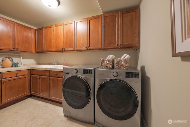 laundry room featuring washer and dryer, sink, and cabinets