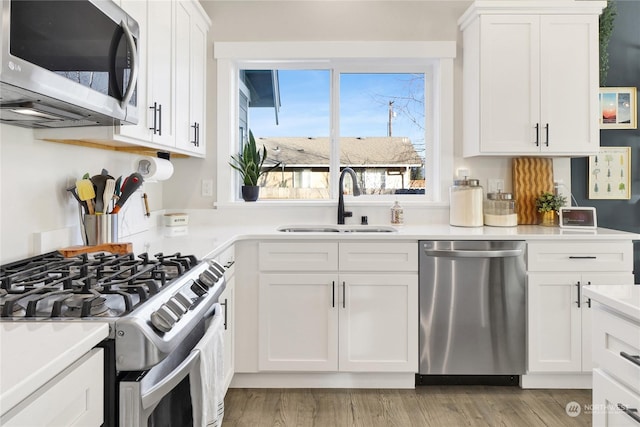 kitchen featuring white cabinetry, appliances with stainless steel finishes, sink, and light hardwood / wood-style flooring