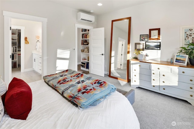 carpeted bedroom featuring connected bathroom and an AC wall unit