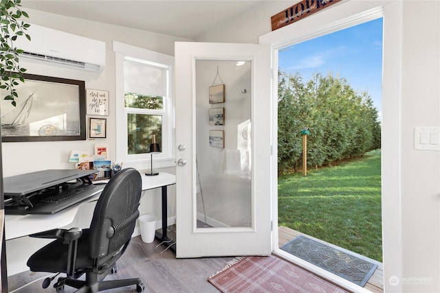 home office with an AC wall unit and hardwood / wood-style floors