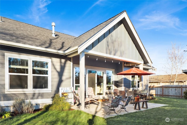 rear view of house with a patio and a yard