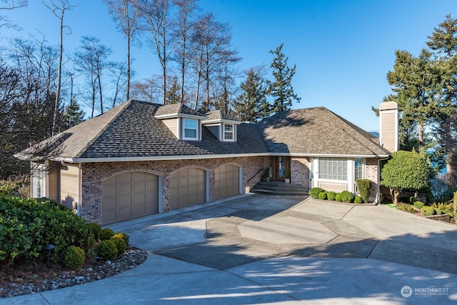 view of front of property featuring an attached garage, concrete driveway, and brick siding