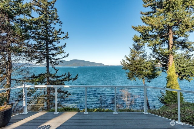 wooden deck featuring a water and mountain view