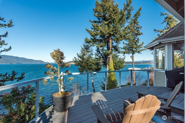 deck with a water and mountain view