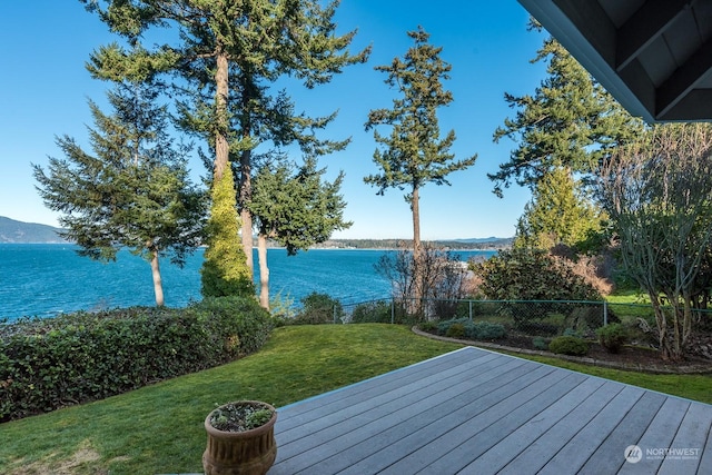 wooden deck with fence, a water and mountain view, and a yard