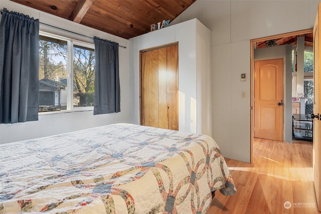 bedroom with lofted ceiling with beams, light hardwood / wood-style flooring, and wooden ceiling