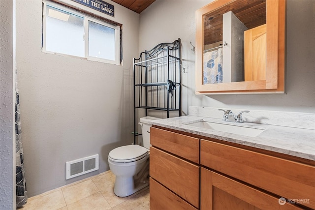 bathroom featuring tile patterned flooring, vanity, and toilet